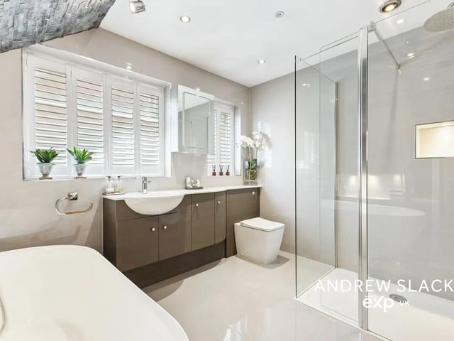 The bathroom features a walk-in rainfall shower and bespoke vanity units.