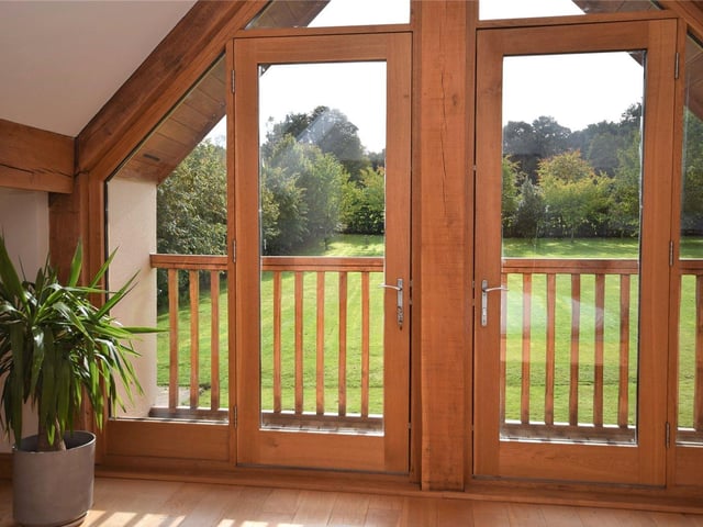 A close-up of the doors that lead out to the covered balcony in the main bedroom of the unique Ravenshead house.