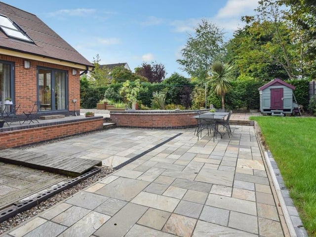 The back garden includes patios, seating areas and a lawn.