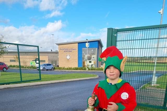 Billy Dawes aged six in his elf suit  and ringing his bell