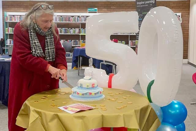 Long-time library member, 87-year-old Averil Higginson, cuts the cake at the 50th birthday celebrations of Sutton Library.