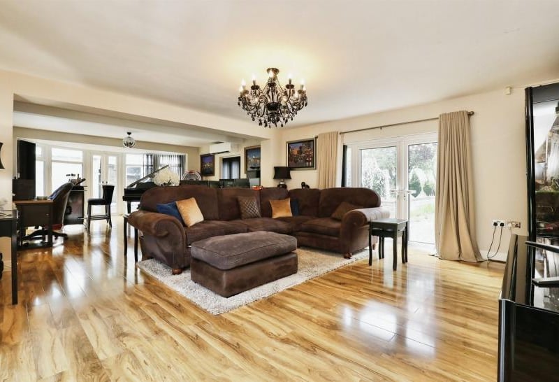 A spectacular lounge at Three Acres, complete with doors leading out to a patio and half-moon double doors leading out to the garden.