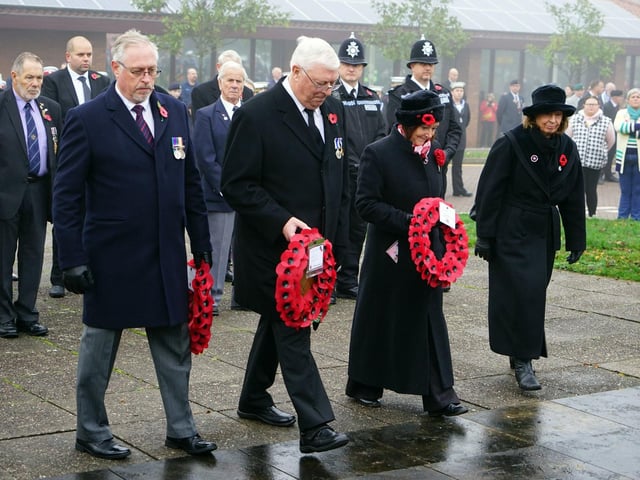 Dignitaries step forward to lay their wreaths