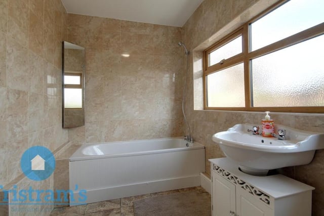 The Ollerton cottage's bathroom sits on the ground floor. A pleasant room, it comprises a fitted bath with shower above, sink basin, vanity unit, WC and full wall-tiling