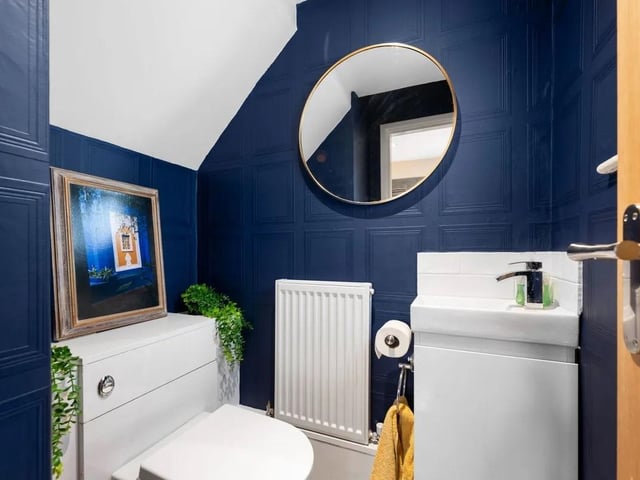 A stylish ground floor cloakroom boasts a bold bespoke décor, with a modern suite comprising a wash basin with handy storage underneath, and there is a low flush w.c. There is a radiator and a uPVC window to the front. Modern tiled flooring finishes the room.