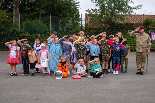 Site Manager Shaun Martwich (right) with children dressed up as their own heroes and learning some marching and saluting skills