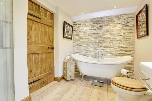 Completing the first floor is this delightful bathroom, with a free-standing bath that has central taps, a hand-held shower head and claw feet. There is also a low-flush WC and wood-effect flooring.
