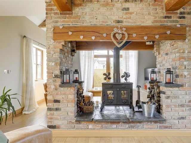 The stunning central exposed brick fireplace with a double-sided log burner creates the perfect cosy space.