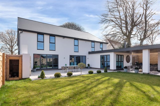 To the rear of property, there is a west-facing, landscaped garden featuring an extensive patio extending the full width of the property and beyond to a large undercover seating area.
