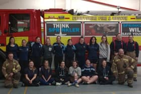 Members of Mansfield under-18s girls rugby team with firefighters in Alfreton.