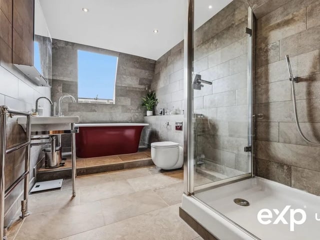 The indulgent bathroom is fitted with a four-piece suite including a freestanding bath and stunning views over the lake