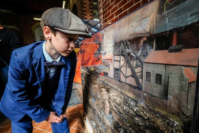A youngster looks at one of the displays with a model railways in.