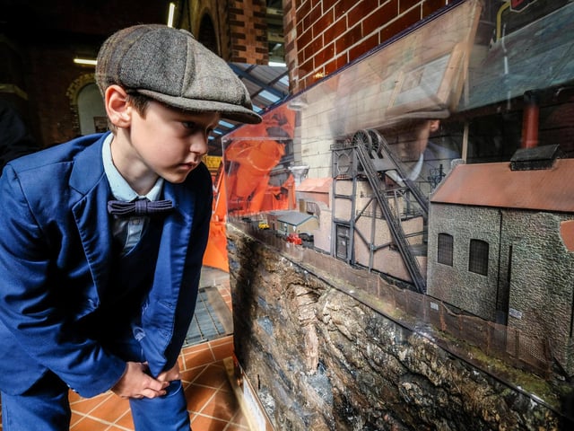 A youngster looks at one of the displays with a model railways in.