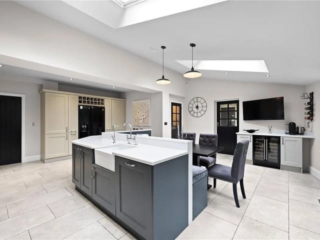 The kitchen/diner has a range of wall and base units with granite work surface over, inset sink and drainer, range master cooker with double oven and warming draws, integrated dishwasher and wine coolers and space for an American fridge freezer. The space has tiled flooring with underfloor heating, doors leading to the boot room, hallway, utility and family room.