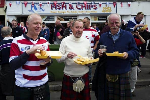 People enjoying a traditional serving of fish and chips.