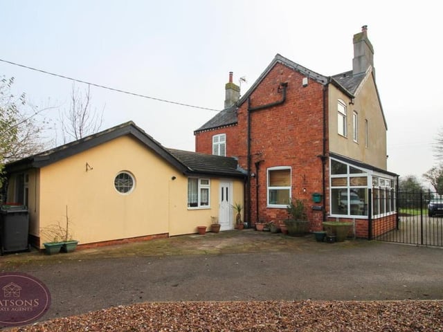 As we step outside, this shot shows the annexe and also a tarmac driveway that leads to wrought iron gates. Beyond the gates is a single garage with power and an up-and-over door.