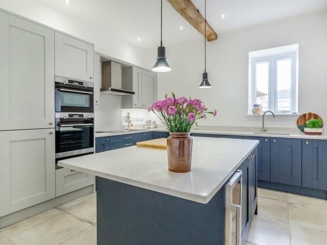 Integrated appliances in the dining kitchen include a combination microwave oven, single oven and warming drawer, AEG four-ring induction hob, fridge/freezer, dishwasher and wine cooler. The room also features an inset one-and-a-half-bowl stainless steel sink with mixer tap and built-in drainer.