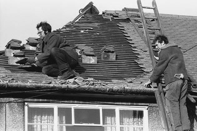 These men have had to climb up to sort the tiles out on this damaged roof, thanks to the storm of 1976!
