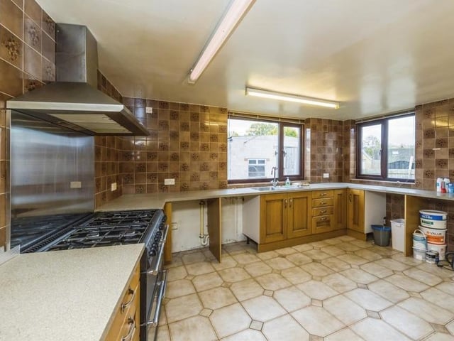 A second shot of the kitchen, which is fitted with matching wall and base units, incorporating a stainless steel sink and drainer with mixer tap. The floor is tiled, while double-glazed windows face the rear and side of the £260,000-plus bungalow.