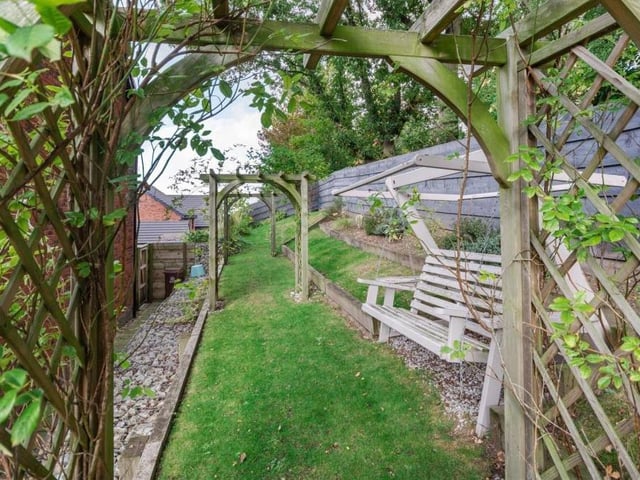 The lawns continue to the side of the house as part of a delightful raised area that passes underneath three feature pergolas and on to the front.