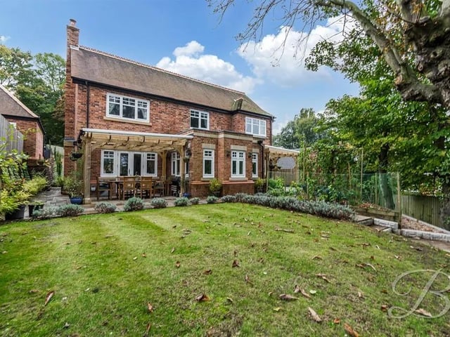 The rear garden is idyllic and features a well-maintained lawn, two pergola covered patio seating areas, vegetable patches, flower beds and raised planters.
