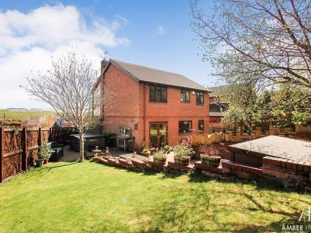 Moving outside now to take a look at the back garden, which has been well crafted. It features a resin patio, and decked and lawned areas, all surrounded by mature shrubbery and planted borders.