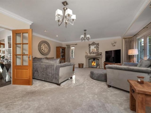 The lounge at the £975,000 house is a spectacular sight, particularly thanks to its stunning stone fireplace with inset long burner. A spacious, dual-aspect room, its French doors lead to a large balcony.
