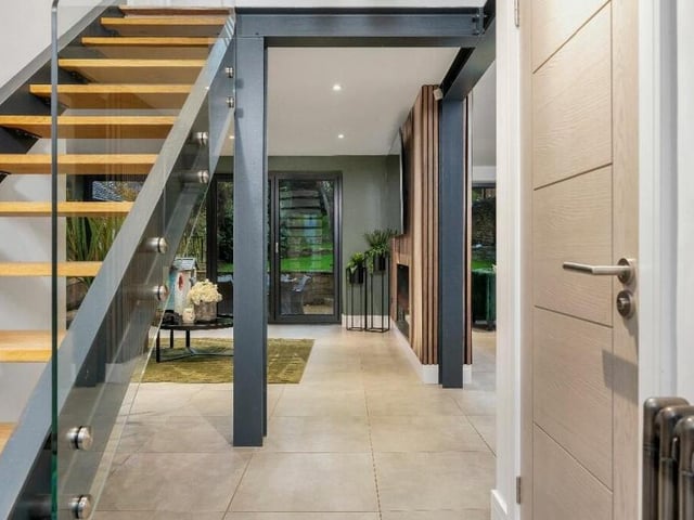 Time to check out the first floor now, which means a return to the hallway and that amazing, floating staircase. With exposed steels, it is matte black, with inset oak steps and a frameless glass balustrade. Cool or what?