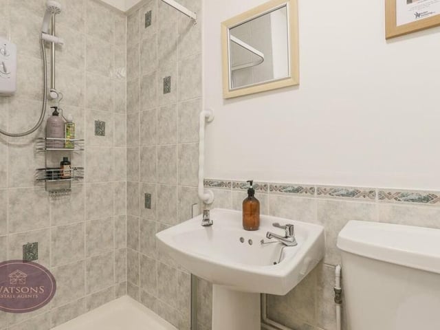 The downstairs WC is incorporated within a shower room, which also includes a shower cubicle with electric shower, a pedestal sink unit, radiator and extractor fan.
