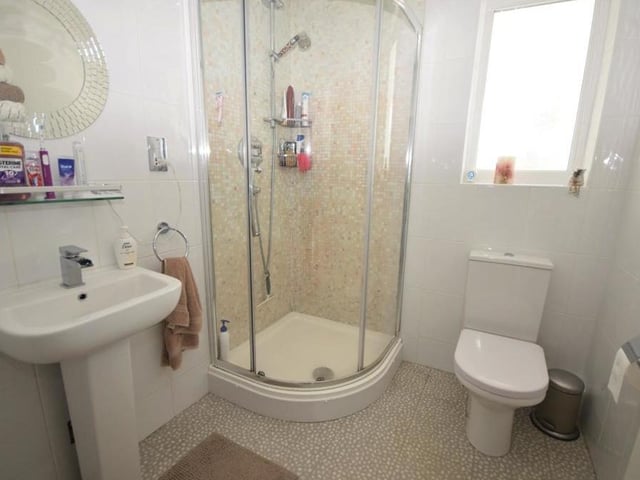 Completing our tour of the ground floor at the Barbers Wood Close property is this shower room. It is fitted with a walk-in shower cubicle, wash basin and low-flush WC, and decorated with tiled walls. There is also a chrome, heated towel-rail.
