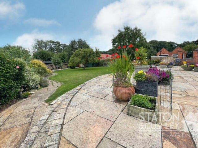 Flowers and shrubs blend in with the patio area