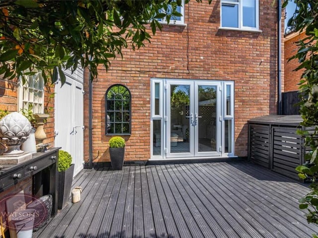 Let's step outside now for a few exterior photos, beginning with the south-west facing rear garden, which features a timber decking seating area, and a timber-built shed with electricity.