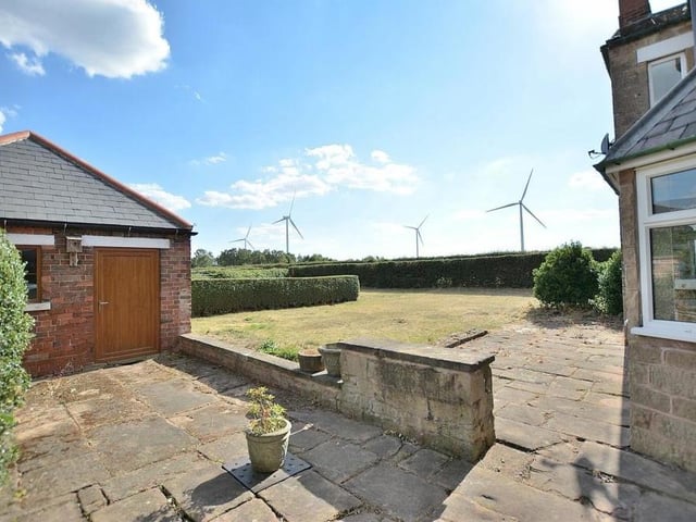 Our gallery now features several shots of the exterior of the property, which sits on a good-sized plot measuring almost 0.3 of an acre. Here is the stone patio, lawn and outbuilding.