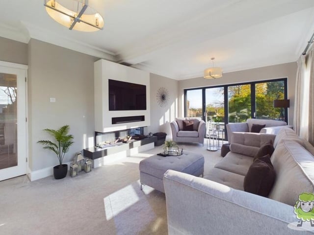 The welcoming lounge is a captivating space, with its modern feature fireplace and an abundance of natural light streaming in through bi-folding doors.