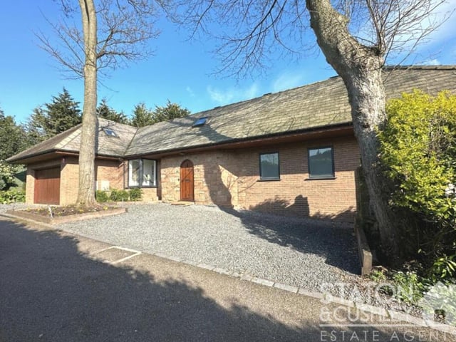 The front of the Mansfield house features a double garage (left), accessed via a driveway.