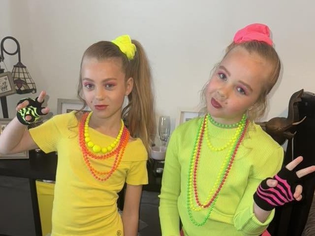 Leigha and Ella are both dressed for the 80s-theme.