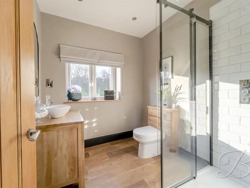 A handy ground floor shower room including a hand wash basin, low flush WC and a tiled shower. Window fitted to the side elevation.