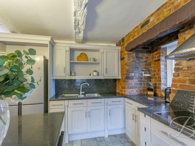 Next stop is the modern kitchen, which is fitted with a stunning range of units and cabinets, plus worktop spaces and an inset sink.