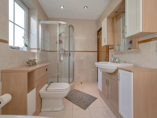 The family bathroom, a modern four-piece suite with chrome fittings, can be found on the first floor. It features a corner panelled bath, a separate shower enclosure and vanity unit with inset wash hand basin, worktops to each side, storage cupboards beneath and a fitted mirror above the sink with cupboards to each side.