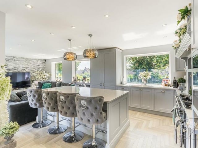 A glamorous central island with breakfast bar, and parquet-style flooring add touches of charm to the kitchen/diner, which is filled with natural light.