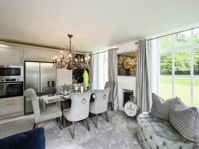 The open-plan living and dining area, with its feature fireplace, provides a warm and inviting atmosphere and also flows seamlessly into the modern kitchen.