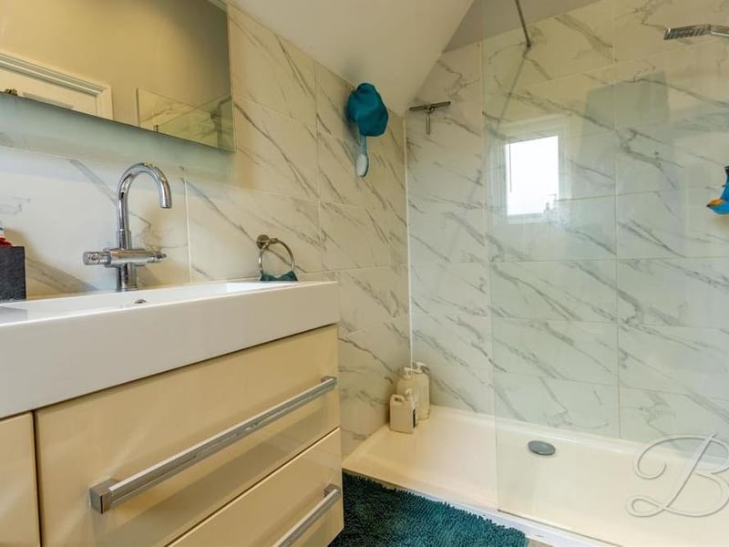 The en suite to the main bedroom comes complete with a walk-in shower, his and hers wash hand basin and a low-flush WC.