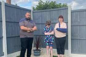 Edwinstowe couple Cliff and Dawn Baker with ten-year-old daughter, Tiona-Jai, by the fence that has been ordered to be taken down.