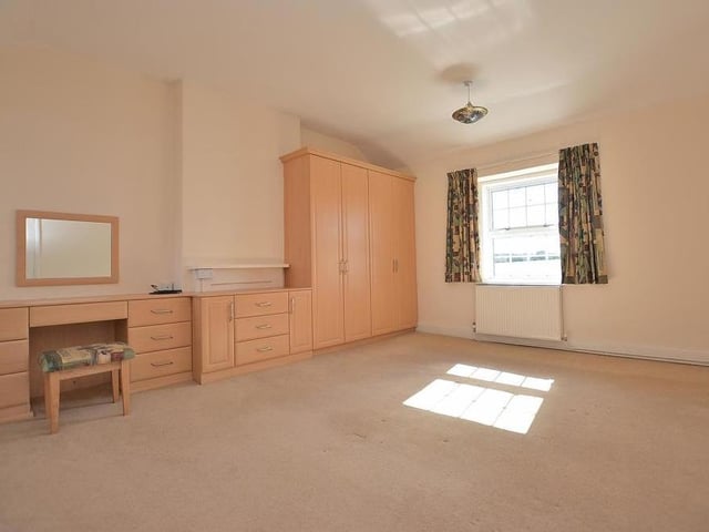 Moving upstairs now, and here is the master bedroom at the £450,000 Rainworth property. A substantial dual-aspect room, it features fitted wardrobes with hanging rails and shelves, plus a large dressing table with drawers.