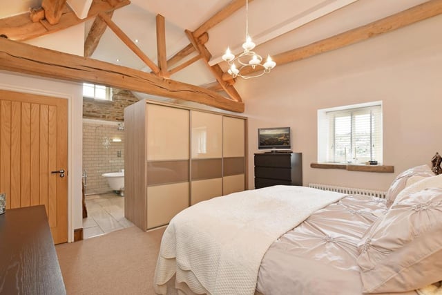 Here's the highly luxurious master bedroom, which features a range of fitted furniture and a vaulted ceiling. It links to an en-suite bathroom.