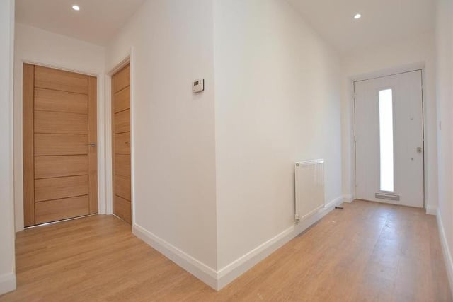 As you step inside the front door, you are greeted by this L-shaped entrance hall. It features an Amtico floor, double power point, radiator, loft hatch, smoke alarm and four ceiling spotlights.