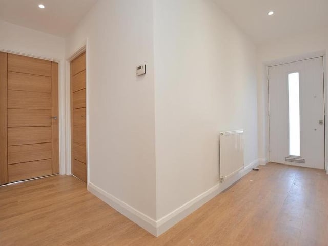 As you step inside the front door, you are greeted by this L-shaped entrance hall. It features an Amtico floor, double power point, radiator, loft hatch, smoke alarm and four ceiling spotlights.