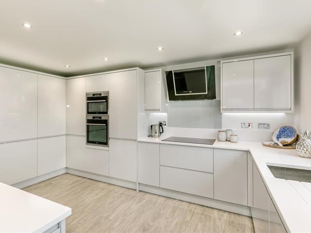 Our last look at the kitchen, which has an inset stainless steel sink with built-in drainer. Matching quartz splashbacks extend to the window sill, while other integrated appliances include a large fridge, separate freezer and wine cooler.
