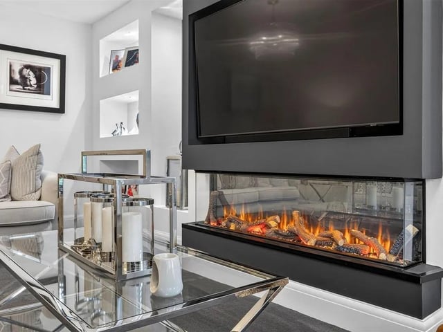 A beautifully appointed reception room for cosy family evenings, having a media wall with modern inset remote controlled log effect flame fire