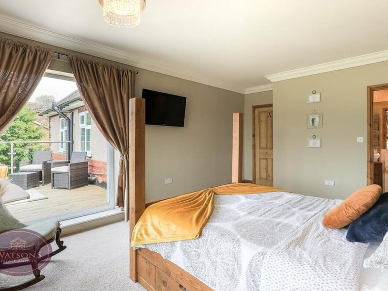 Four double bedrooms sit on the first floor of the £700,000 Jacksdale house, most notably this primary one, which includes access to a balcony overlooking the rear garden, and an en suite shower room.